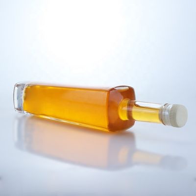 Botella de vidrio de licor de forma redonda de 700 ml con logotipo personalizado y acabado de corcho