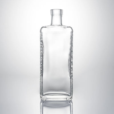 Botella de licor de vidrio transparente con cuerpo en relieve y tapon de corcho