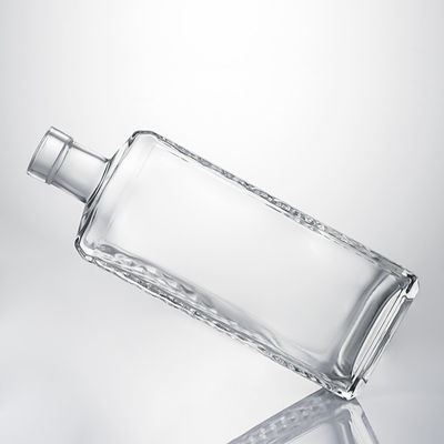 Botella de licor de vidrio transparente con cuerpo en relieve y tapon de corcho